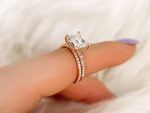 east west set emerald cut solitaire with diamonds on shank and matching diamond band on ring finger angle