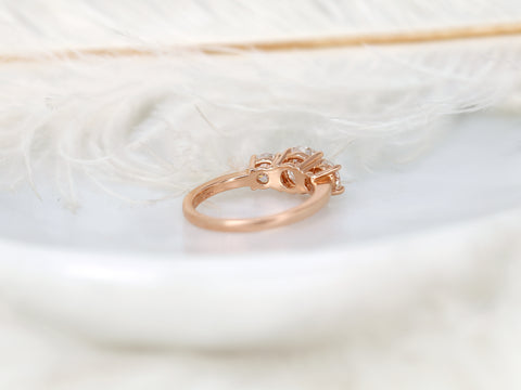 Close-up of a hand wearing a three-stone moissanite ring from back view