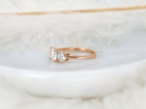 Rose gold ring with three moissanite on a soft white background