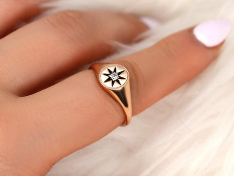 14kt gold signet ring with star design and small diamond center worn on finger against soft background