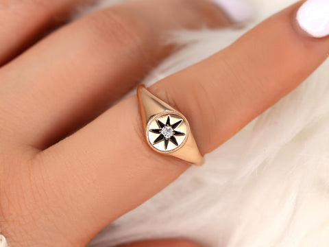 14kt gold ring with star motif and central diamond detail worn on finger over soft white background
