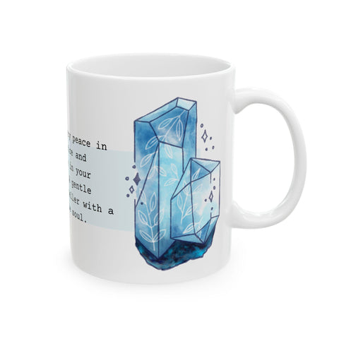 White ceramic mug with blue crystal illustration and partial inspirational text in a soft artistic style