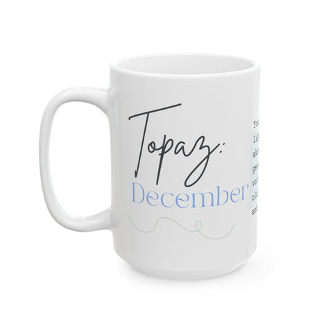 White ceramic mug with "Topaz: December" text in black and blue script on front side