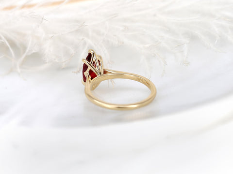 Delicate 14kt gold ring featuring a marquise-cut ruby solitaire in a minimalist setting on a soft background