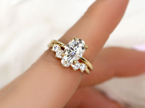 Oval moissanite engagement ring with 14kt gold band and a matching curved diamond-accented wedding band set