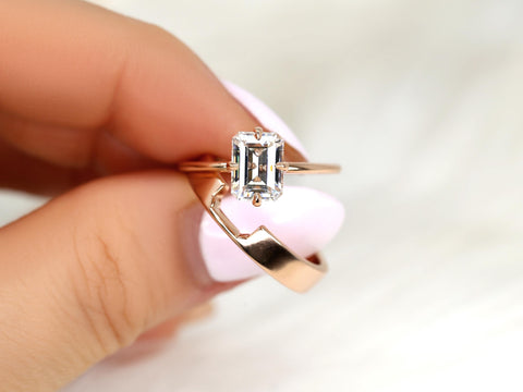 Close-up of two 14kt gold rings, one with an emerald cut moissanite solitaire in elegant bridal set style
