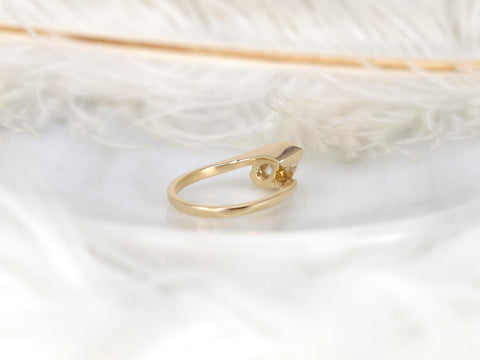 14kt gold ring with a tilted pear-shaped moissanite solitaire set on a sleek polished band