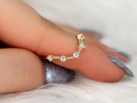 Delicate 14kt gold ring with five round diamonds arranged in a unique curved design on finger close-up