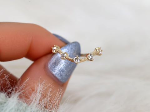 Delicate 14kt gold ring with five small sparkling diamonds arranged in a geometric zigzag pattern held by hand