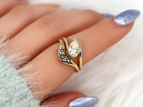 14kt gold ring set with tilted pear moissanite and star-accented band, styled as a unique bridal design