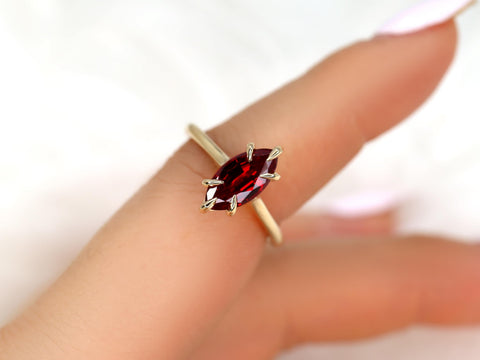 Close-up of hand wearing 14kt gold ring with marquise-shaped deep red ruby solitaire on slender band