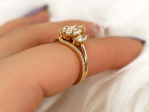 Three-stone marquise moissanite bridal set with diamond-accented curved 14kt gold band on finger close-up