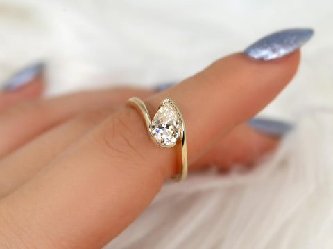 14kt gold ring with a tilted pear-shaped moissanite solitaire, styled on a finger for engagement or fine jewelry gift