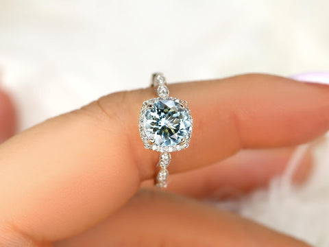 Close-up of a hand wearing an 8mm aquamarine center stone ring with diamond accents and milgrain cushion halo design