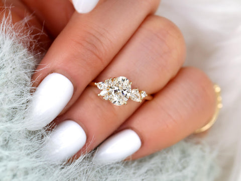 Diamond ring on a hand with white nail polish on a soft background