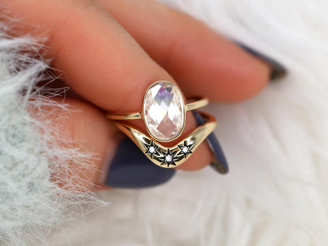 moissanite rose cut oval ring paired with a three diamond celestial curved band in gold on pointer finger