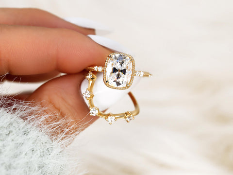 antique cushion engagement ring with button back paired with a curved diamond spaced band pinched between finger