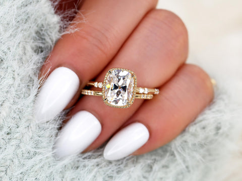 antique cushion button back ring with milgrain edge paired with a open diamond band with pointed opening shown on ring finger over light blue sleeve