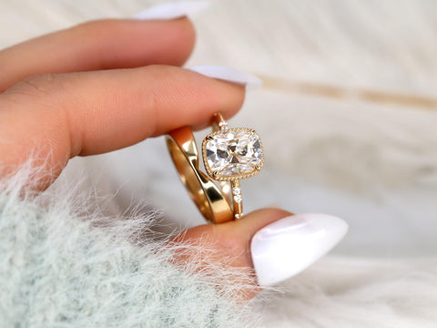 antique cushion solitaire with button back, claw prongs, and diamond accents on band. the ring is paired with a chevron solid gold band held by two fingers