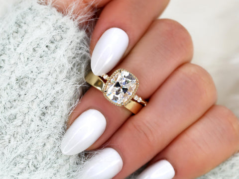 antique cushion solitaire with button back, claw prongs, and diamond accents on band. the ring is paired with a chevron solid gold band on middle finger over sleeve