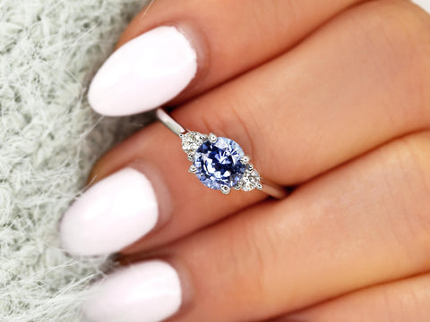 cornflower blue sapphire trilogy ring on middle finger over sleeve