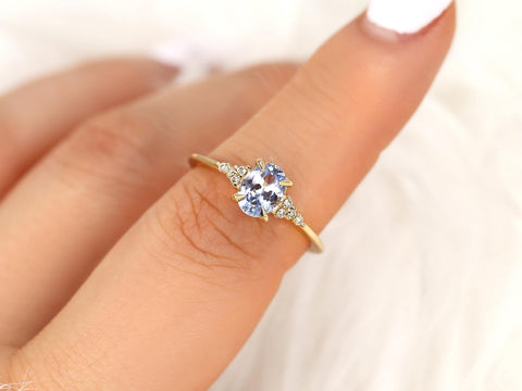 oval cornflower lilac sapphire cluster ring with dainty diamonds held on pointer finger