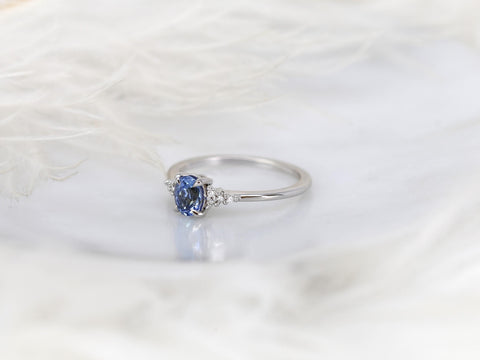 oval cluster ring with cornflower sapphire center stone over white background angled left