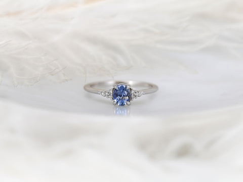 oval cluster ring with cornflower sapphire center stone over white background
