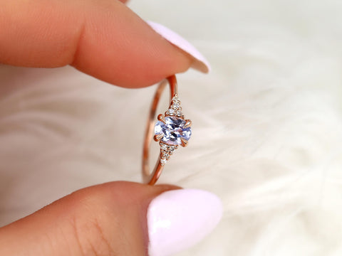 oval cluster sapphire ring with lavender sapphire in rose gold held between two fingers