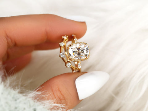antique cushion engagement ring with button back paired with a curved diamond spaced band pinched between fingers