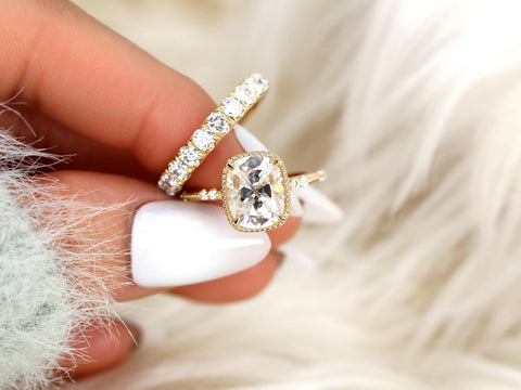antique cushion cut button back ring with accent diamonds paired with a thick diamond band pinched between fingers