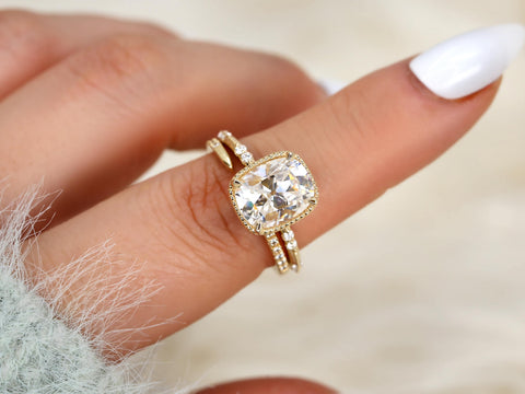 antique cushion button back ring with milgrain edge paired with a open diamond band with pointed opening shown on pointer finger