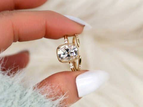 antique cushion button back ring with milgrain edge paired with a open diamond band with pointed opening shown between two fingers