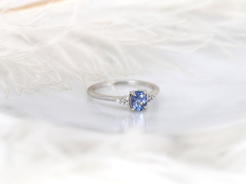 oval cluster ring with cornflower sapphire center stone over white background angled