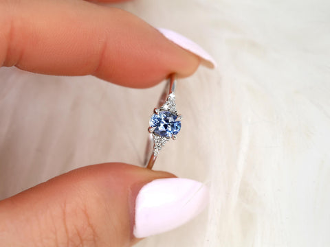 oval cluster ring with cornflower sapphire center stone on pinched finger