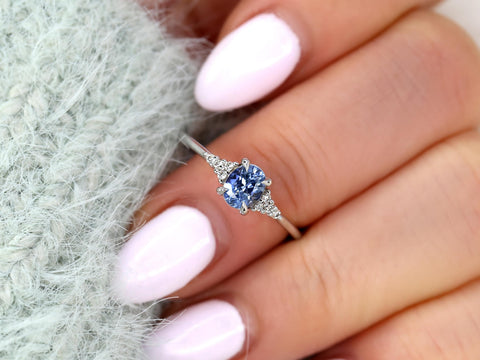 oval cluster ring with cornflower sapphire center stone on middle finger over sleeve