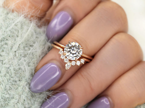 round solitaire moissanite paired with a unique curved band in rose gold on middle finger