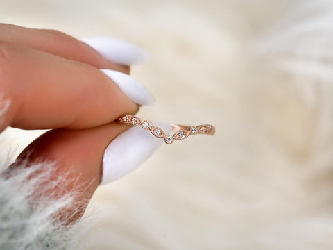 chevron dainty diamond band with vintage detail between two fingers in gold
