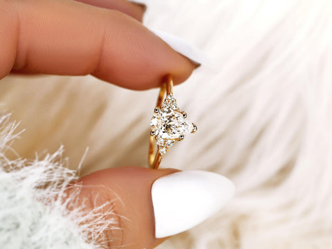 pear cut lab diamond ring with cluster diamonds pinched between fingers